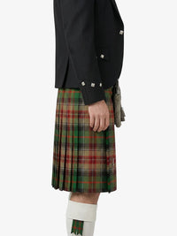 Person wearing a black jacket and green plaid kilt on a white background