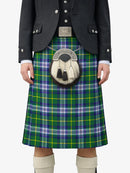 Person wearing a green plaid kilt with a black jacket and white socks on a white background