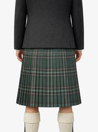 Person wearing a dark gray jacket and green plaid kilt on a white background