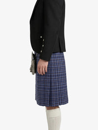 Person wearing a black blazer and blue plaid kilt on a white background