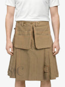 Person wearing a brown pleated skirt with large front pockets on a white background