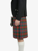 Person wearing a black jacket and red plaid kilt on a white background