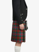 Person wearing a black blazer and red plaid kilt on a white background