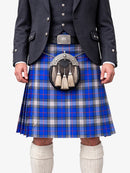 Person wearing a blue plaid kilt with a dark jacket and white socks on a white background