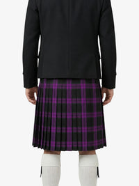 Person wearing a black jacket and purple plaid kilt on a white background