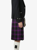 Person wearing a black jacket and purple plaid kilt on a white background