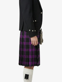 Person wearing a black jacket and purple plaid kilt on a white background
