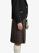 Person wearing a black jacket and plaid kilt on a white background