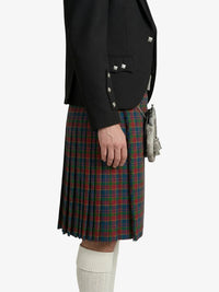 Person wearing a black jacket and plaid kilt on a white background