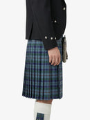 Person wearing a black jacket and plaid kilt on a white background
