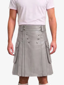 A person wearing a light gray faux-leather kilt with silver-tone metal snap details and side cargo pockets, paired with a white t-shirt against a plain white background.