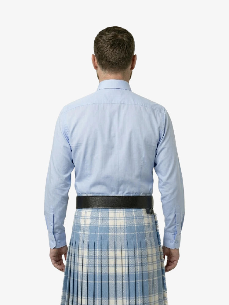 Man wearing a light blue shirt and plaid kilt on a white background