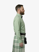 Man wearing a green shirt and plaid kilt on a white background