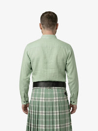 Man wearing a green shirt and plaid kilt on a white background