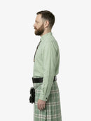 Man wearing a green shirt and plaid kilt on a white background