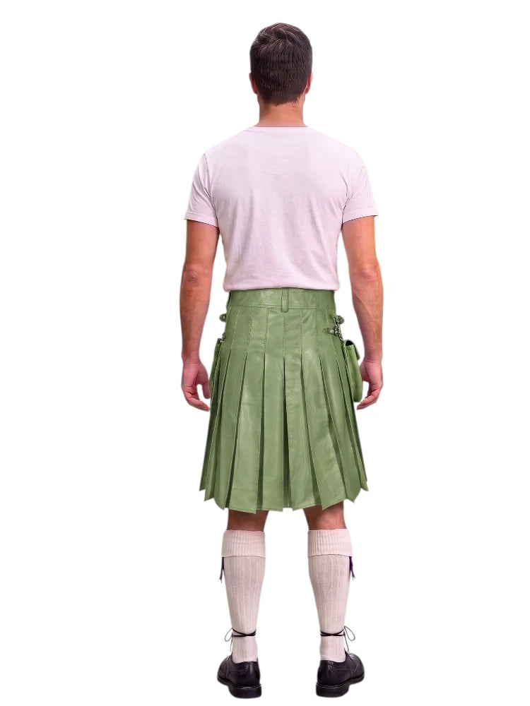 A man shown from the back wearing a light green pleated kilt, a pale pink t-shirt, cream-colored knee-high socks, and black shoes, set against a plain white background.