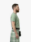 Man wearing a green t-shirt and plaid kilt on a white background