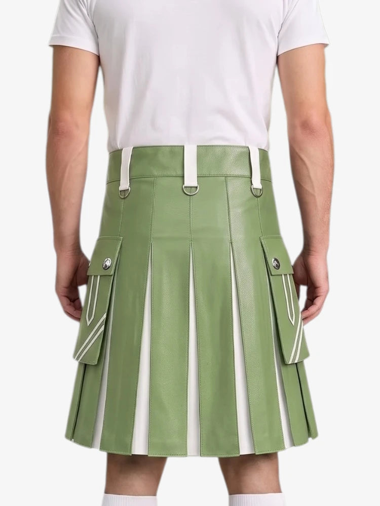 A model from the back wearing a sage green faux-leather pleated kilt with white contrast panels and silver-tone hardware, paired with a white t-shirt.