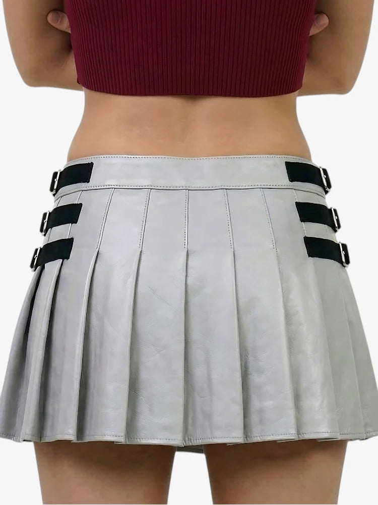 Gray pleated skirt with black buckles worn by a person on a white background