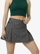 Person wearing a green crop top and patterned skirt on a white background