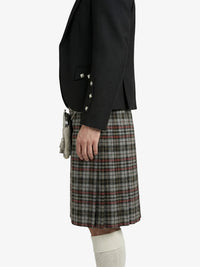 Person wearing a black jacket and plaid kilt on a white background