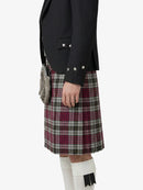 Person wearing a black jacket and plaid kilt on a white background