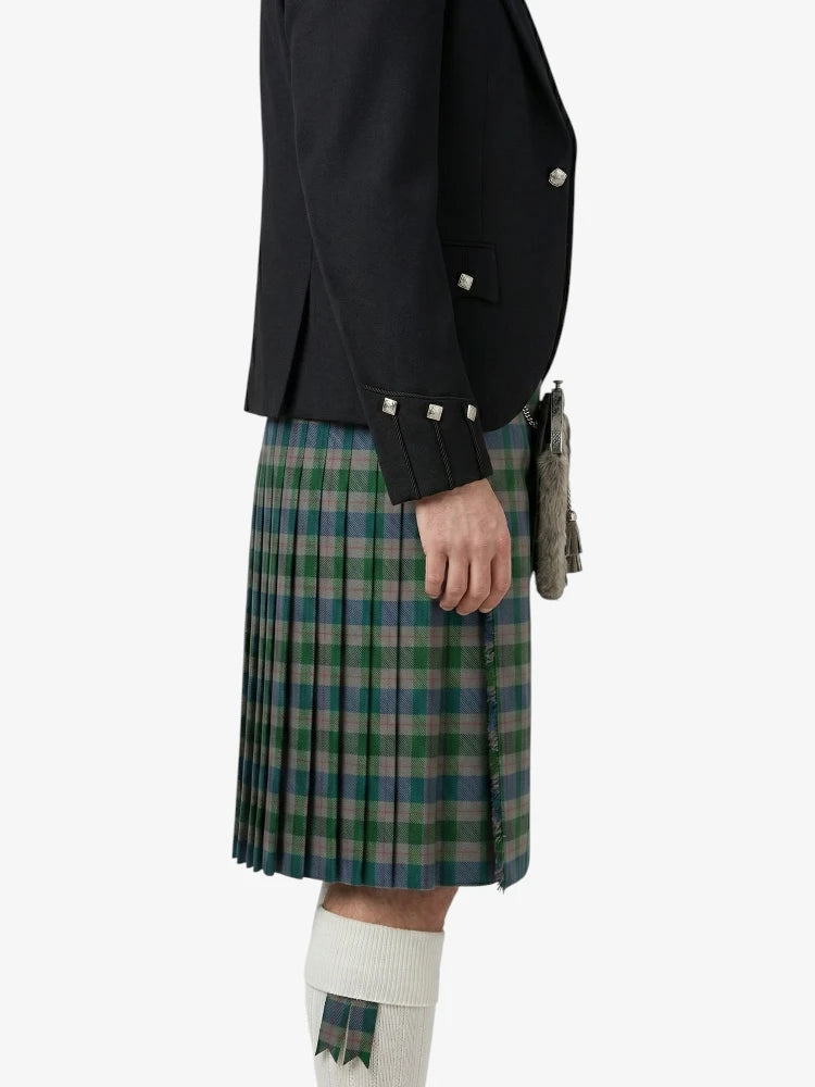 Person wearing a black jacket and green plaid kilt on a white background