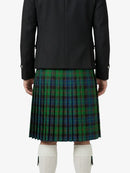 Person wearing a black jacket and green plaid kilt on a white background