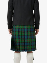 Person wearing a black jacket and green plaid kilt on a white background
