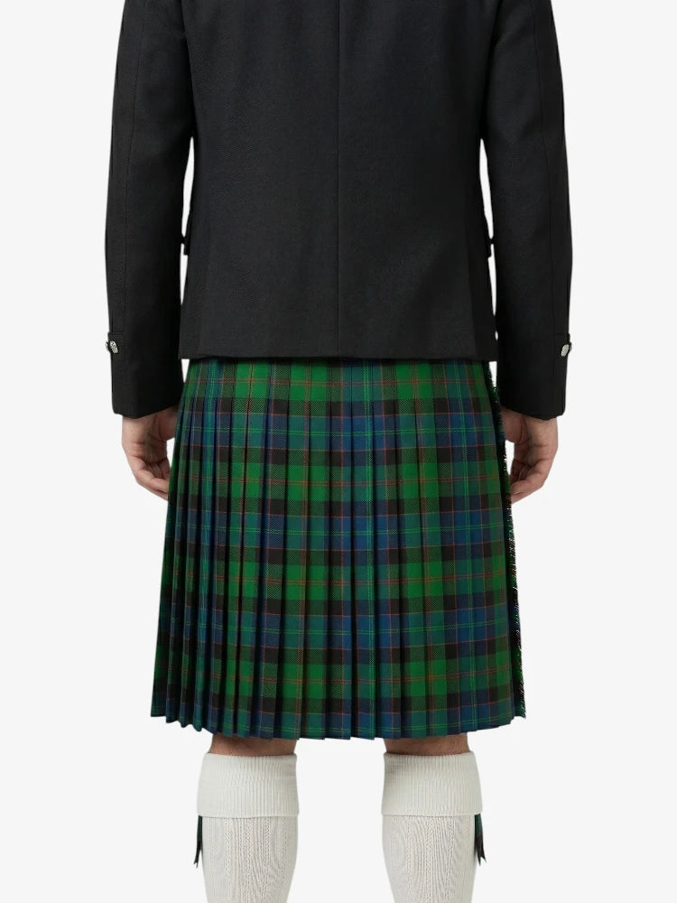 Person wearing a black jacket and green plaid kilt on a white background