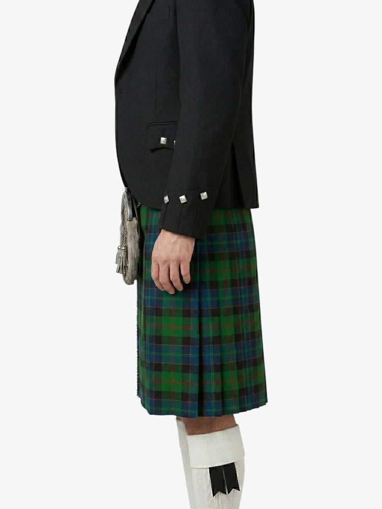 Person wearing a black jacket and green plaid kilt on a white background