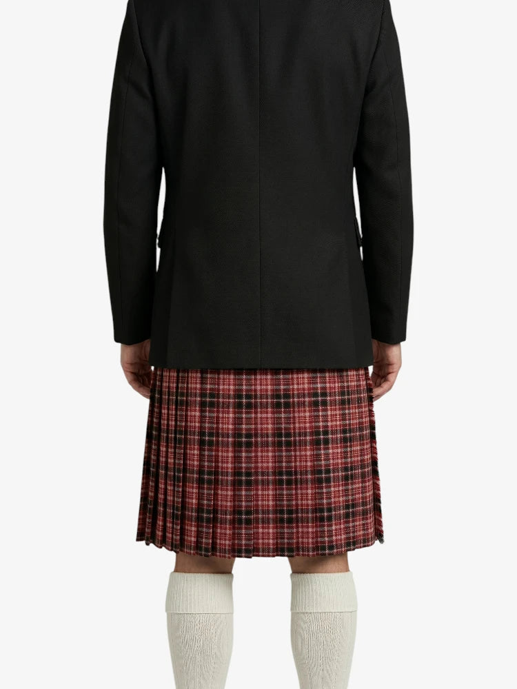 Person wearing a black jacket and red plaid kilt on a white background