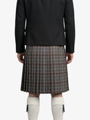 Person wearing a black jacket and plaid kilt on a white background