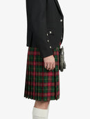 Person wearing a black jacket and red plaid kilt on a white background