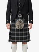 Person wearing a traditional Scottish kilt with a jacket on a white background