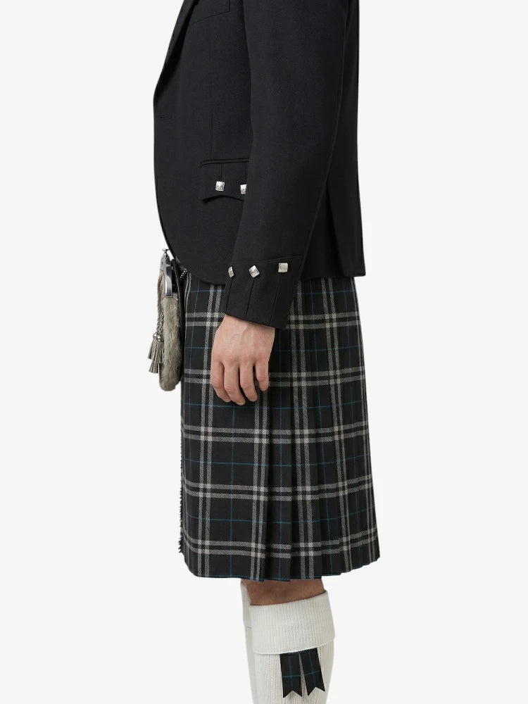 Person wearing a black jacket and plaid kilt on a white background
