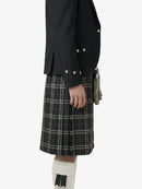 Person wearing a black jacket and plaid kilt on a white background