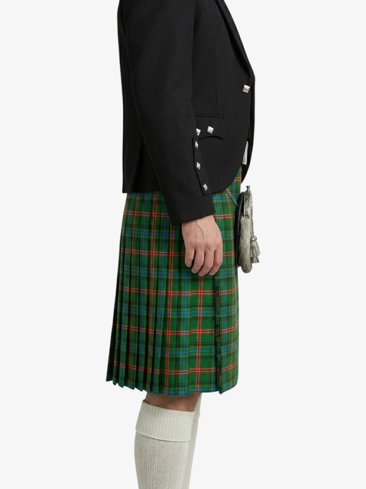 Person wearing a black blazer and green plaid kilt on a white background