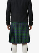 Person wearing a black jacket and green plaid kilt on a white background