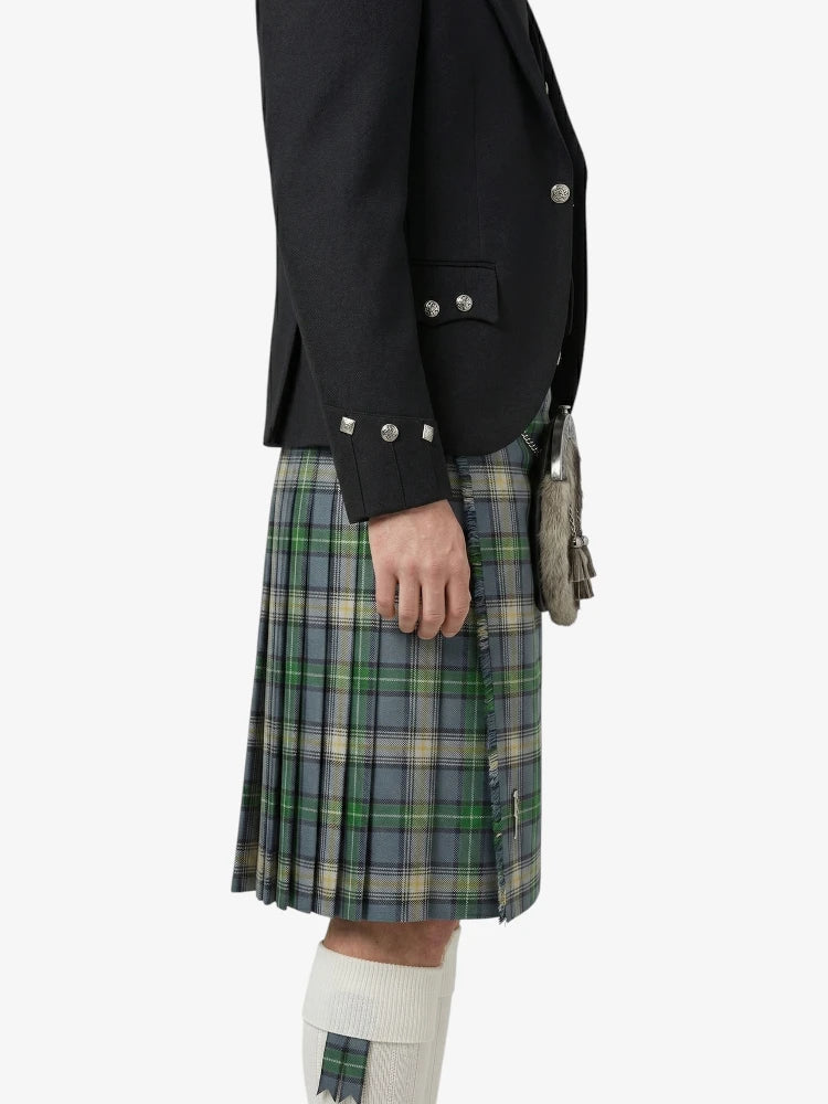 Person wearing a black jacket and plaid kilt on a white background