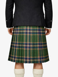 Person wearing a dark jacket and green plaid kilt on a white background