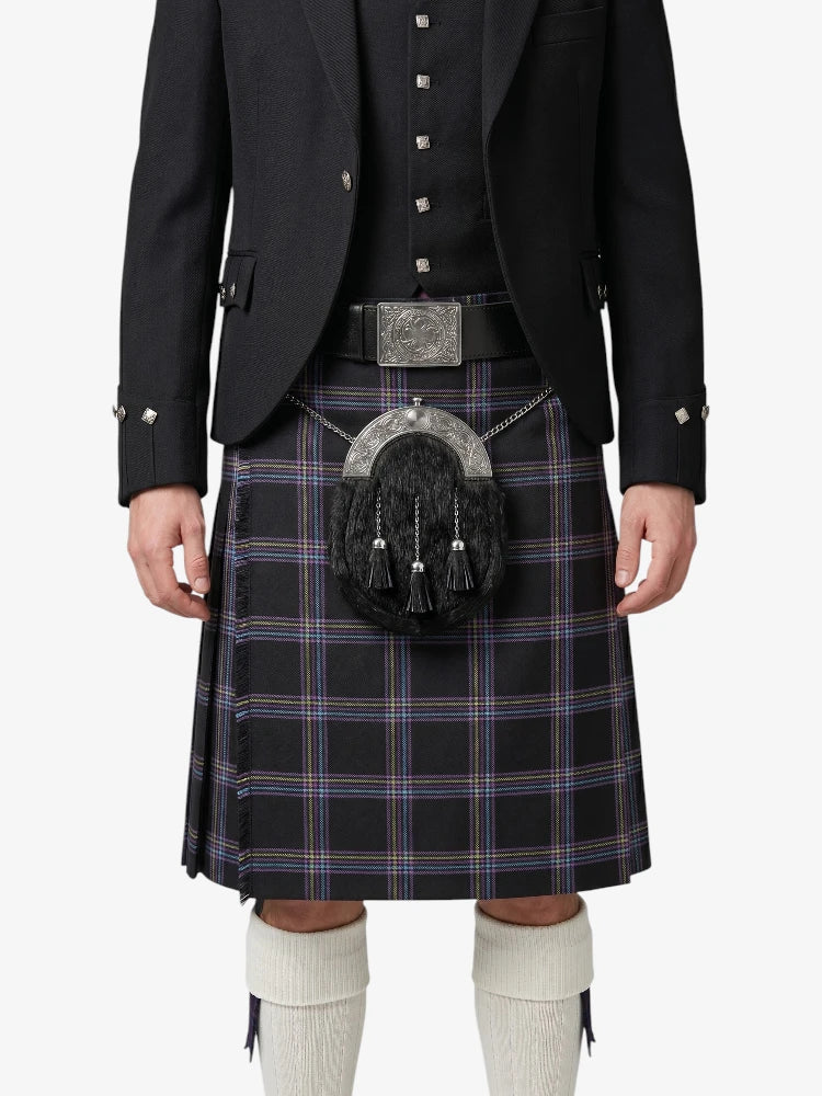 Person wearing a black jacket, plaid kilt, and white knee-high socks on a white background