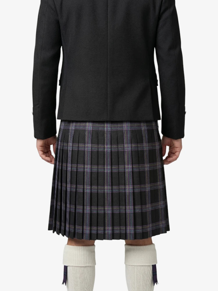 Person wearing a black jacket and plaid kilt on a white background