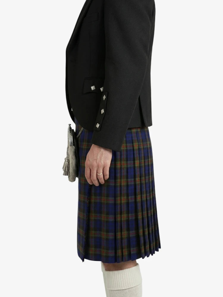 Person wearing a black blazer and plaid kilt on a white background