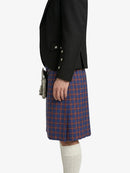 Person wearing a black jacket and blue plaid kilt on a white background