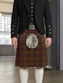 Person wearing a traditional Scottish kilt with a tartan pattern in a room with large windows.
