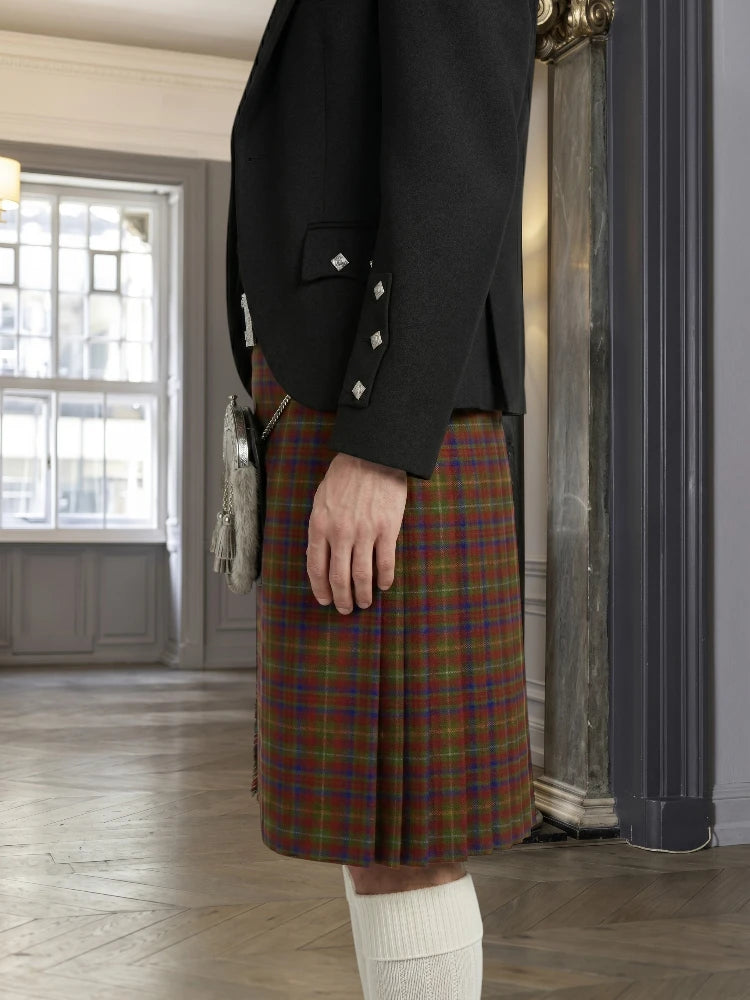 Person wearing a black jacket and plaid kilt in an indoor setting