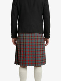 Person wearing a black jacket and plaid kilt on a white background