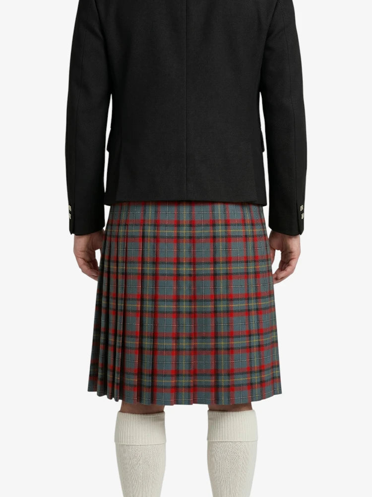 Person wearing a black jacket and plaid kilt on a white background