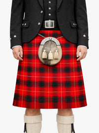 Person wearing a red tartan kilt with a black jacket and white knee-high socks on a white background